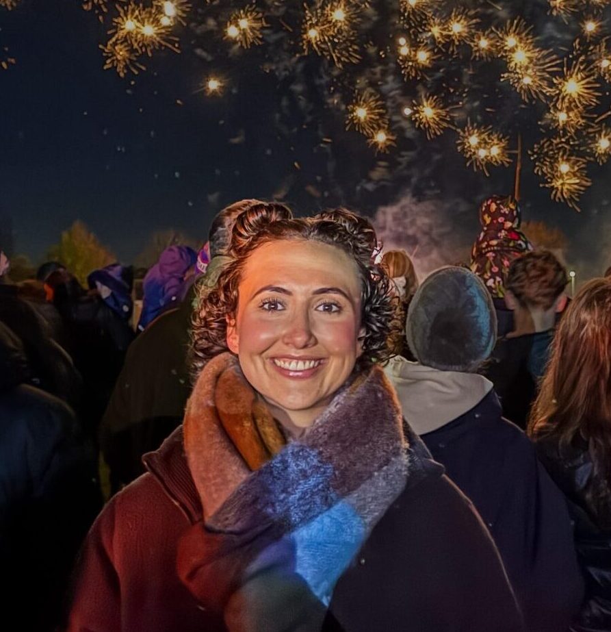 Smiling young woman in front of fireworks, stage 2 stomach cancer survivor